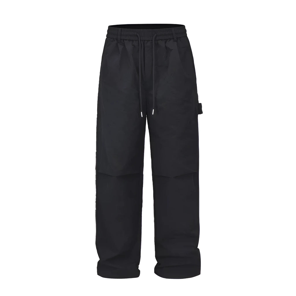 Black men's baggy paratrooper trousers with a drawstring elastic waistband on a plain background.