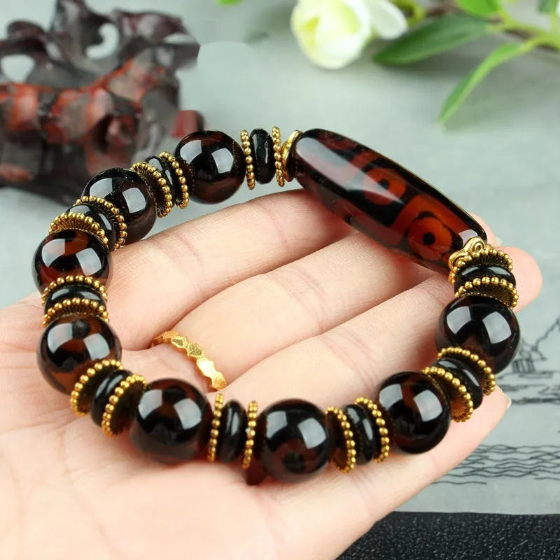 Distressed agate bracelet with traditional Tibetan dzi beads including three-eye and Nine Eyes designs.