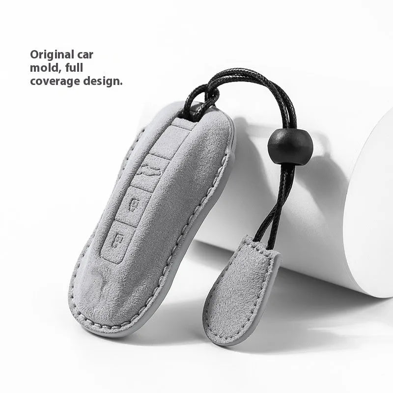 Suede car key cover in cement grey, dark green, light grey, and orange colour options