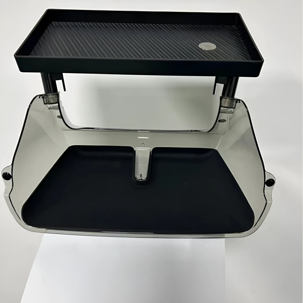 Black ABS plastic storage box installed under the touchscreen in a Tesla Model Y centre console.