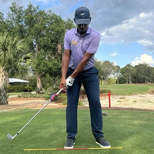 Plastic golf swing plane training aid shown on a solid background.