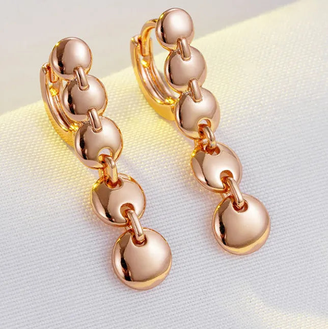 Long gold retro circle earrings with woven chain design, shown from the side.