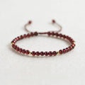 Women's freshwater pearl and geometric crystal bracelet on a black elastic braided rope.