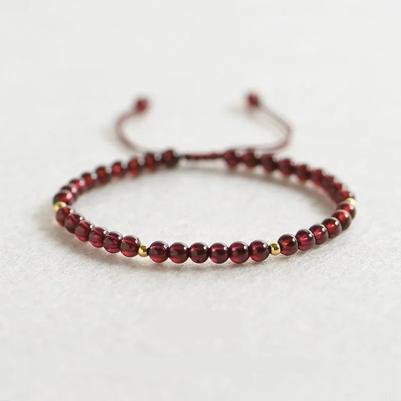 Women's freshwater pearl and geometric crystal bracelet on a black elastic braided rope.