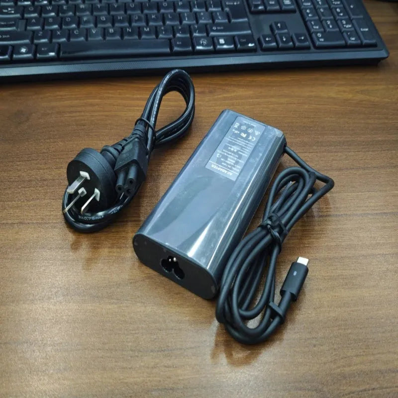 Black 65W USB-C laptop power adapter with six international plug cords for UK US EU AU SA and CN sockets
