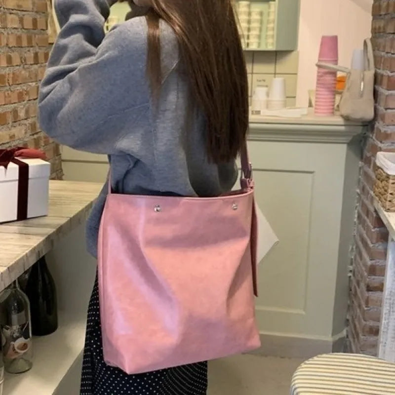 Corduroy one-shoulder commuter bag in pink colour showing textured fabric and structured shape