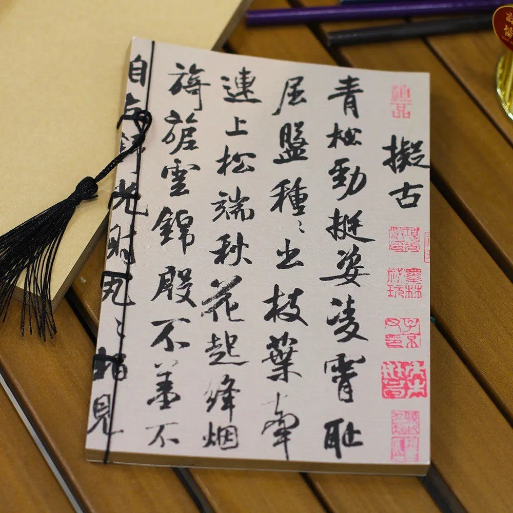 A5 antique wire-bound notebook with glossy embossed cover featuring a retro painting design, shown open.