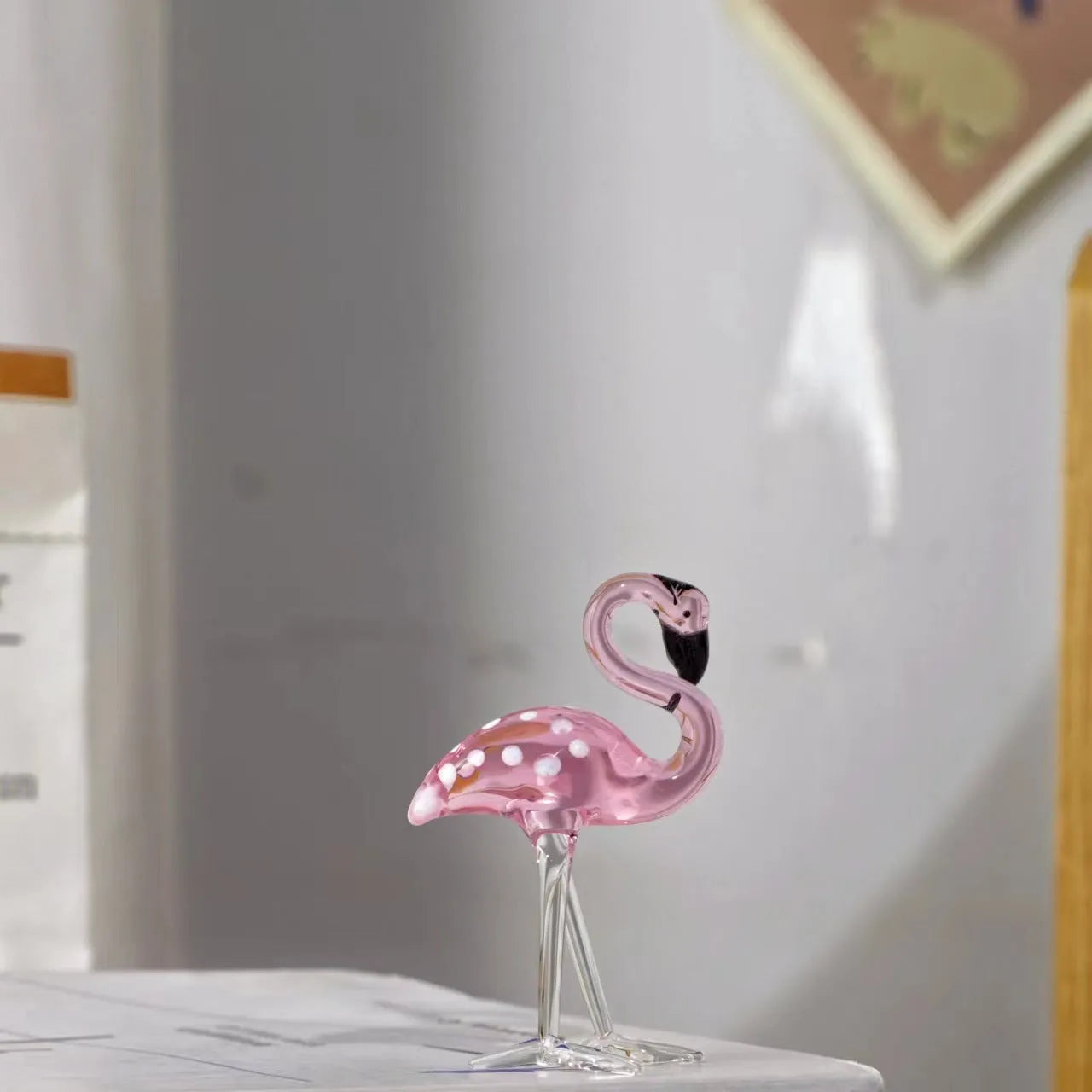 Pink and white crystal decorative flamingo table prop on a modern shelf