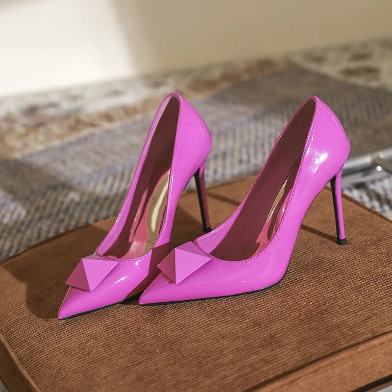 Pink patent leather women's stiletto heels with pointed toe and rivet buckle fastening