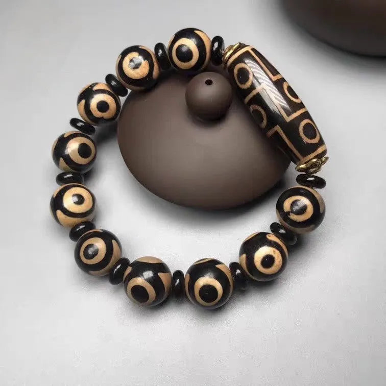 Distressed agate bracelet with traditional Tibetan dzi beads including three-eye and Nine Eyes designs.