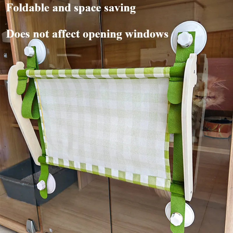 Wooden frame cat hammock with linen mat attached to a window via suction cups, shown in pink colour.