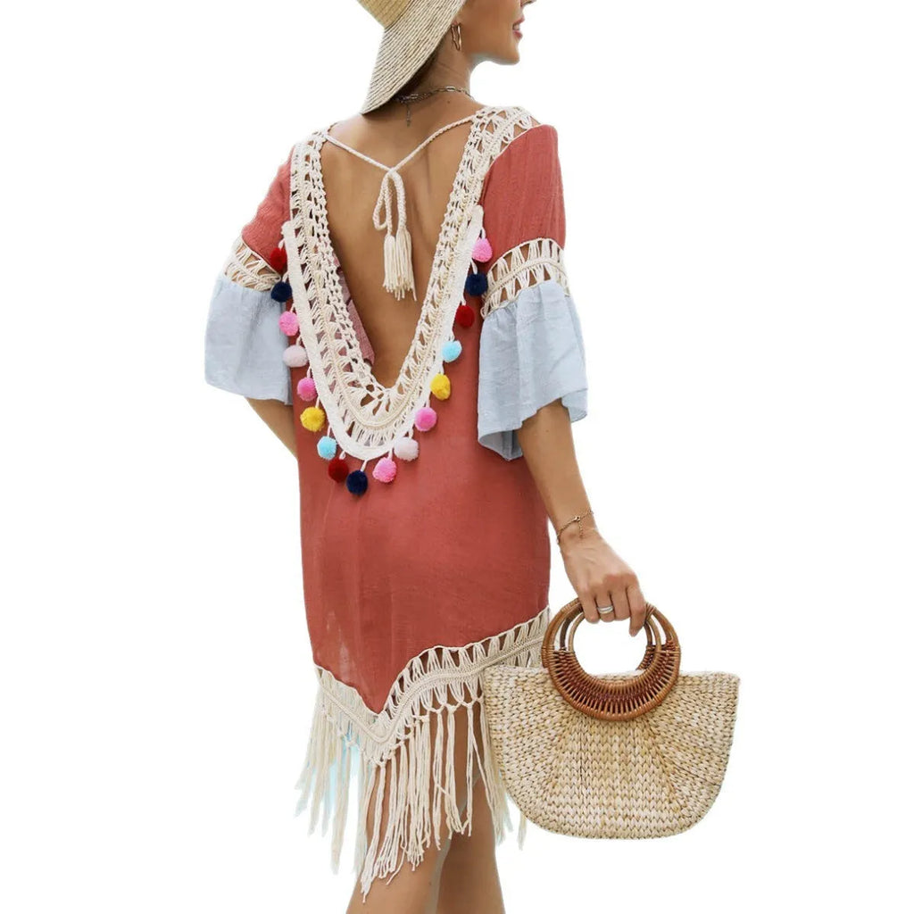 Orange floral pattern beach overskirt with hand crochet detail and cotton tassels laid flat.