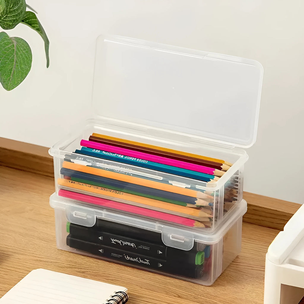 Transparent plastic stationery storage box containing pencils, colour leads, and art supplies