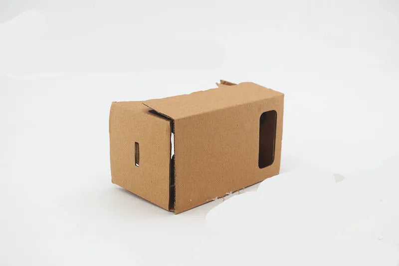 Pink and white foldable cardboard VR glasses headset for smartphones, showing 3D lenses and rubber head strap.