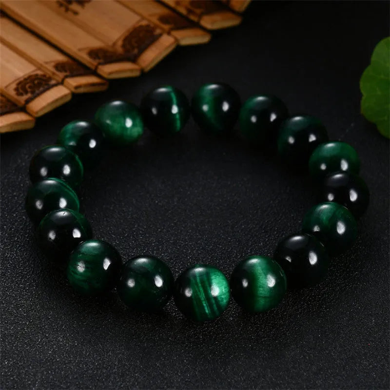 Green tiger eye gemstone bracelet with geometrically polished beads on a white background.