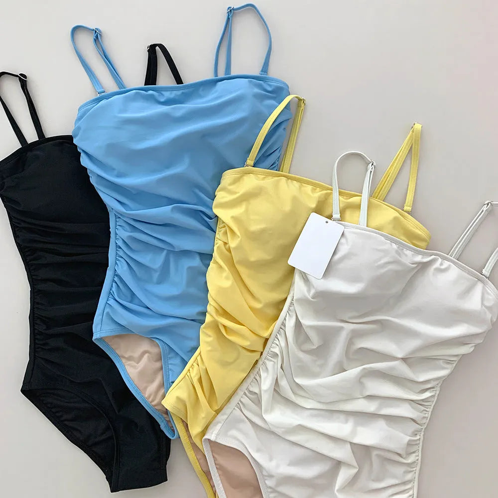 Sling style one-piece swimsuit with belly pleats in a slim fit, shown in blue colour