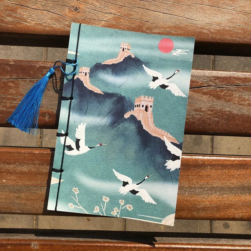 A5 antique wire-bound notebook with glossy embossed cover featuring a retro painting design, shown open.