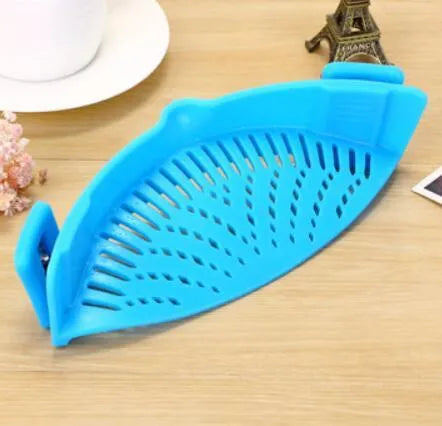 Silicone clip-on funnel strainer attached to kitchen pot for draining liquids