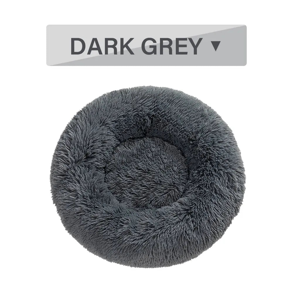 Fluffy donut-shaped dog bed in long plush material, showing raised rim and central cushion.