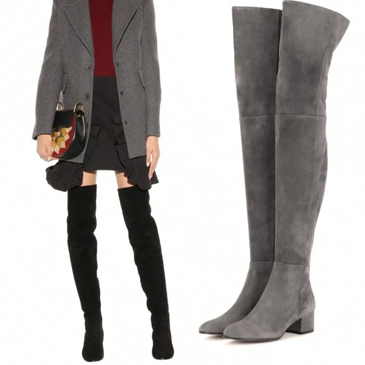 Grey women's suede over-the-knee flat boots with pointed toe and low thick heel on a rubber sole.