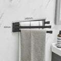 Black folding towel bar mounted on a bathroom wall with no visible screws or drill holes.