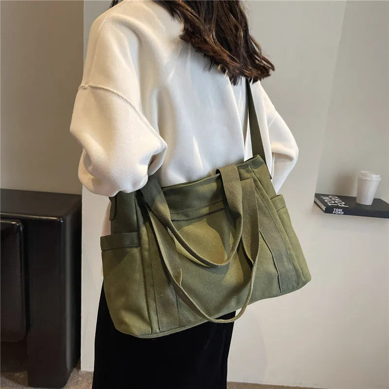 Solid colour polyester tote bag with large capacity and a mobile phone pocket.