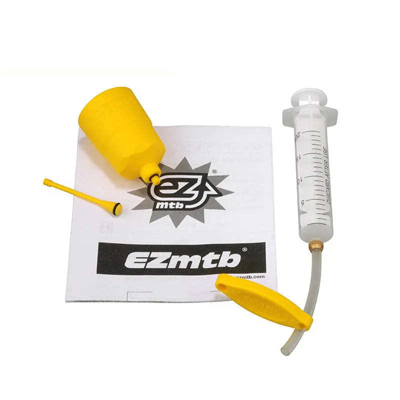 EZmtb bicycle hydraulic disc brake bleed kit with syringes, adapters, and tools on a workbench