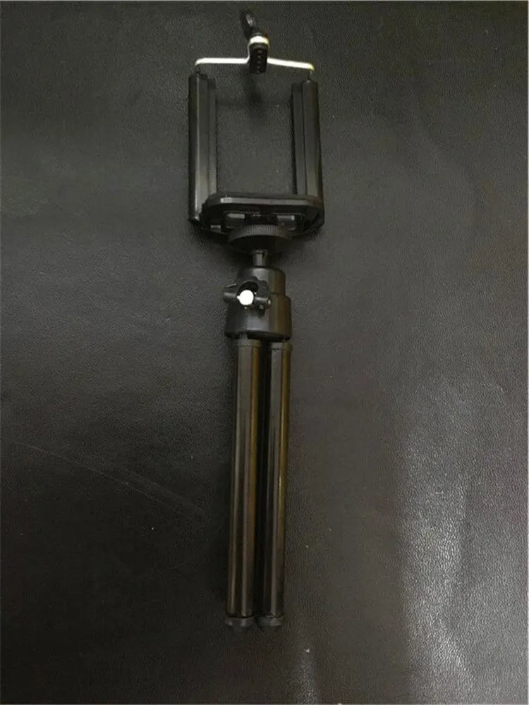 Black desktop phone holder with a two-section adjustable bracket arm holding a mobile phone.