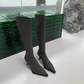 Women's black pointed-toe below-the-knee boots with a stiletto heel and a back zip fastening.