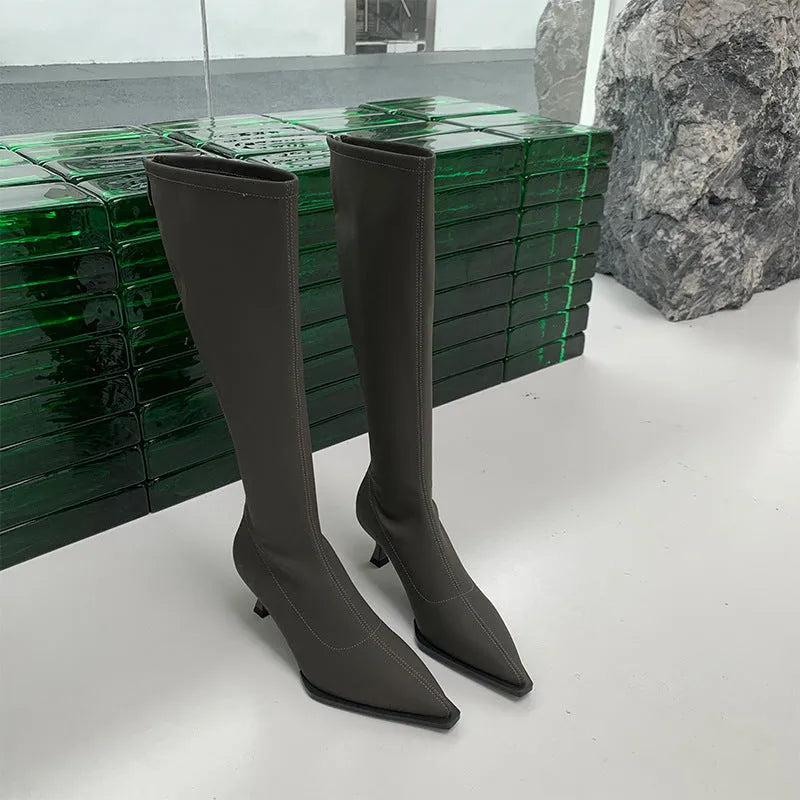 Women's black pointed-toe below-the-knee boots with a stiletto heel and a back zip fastening.