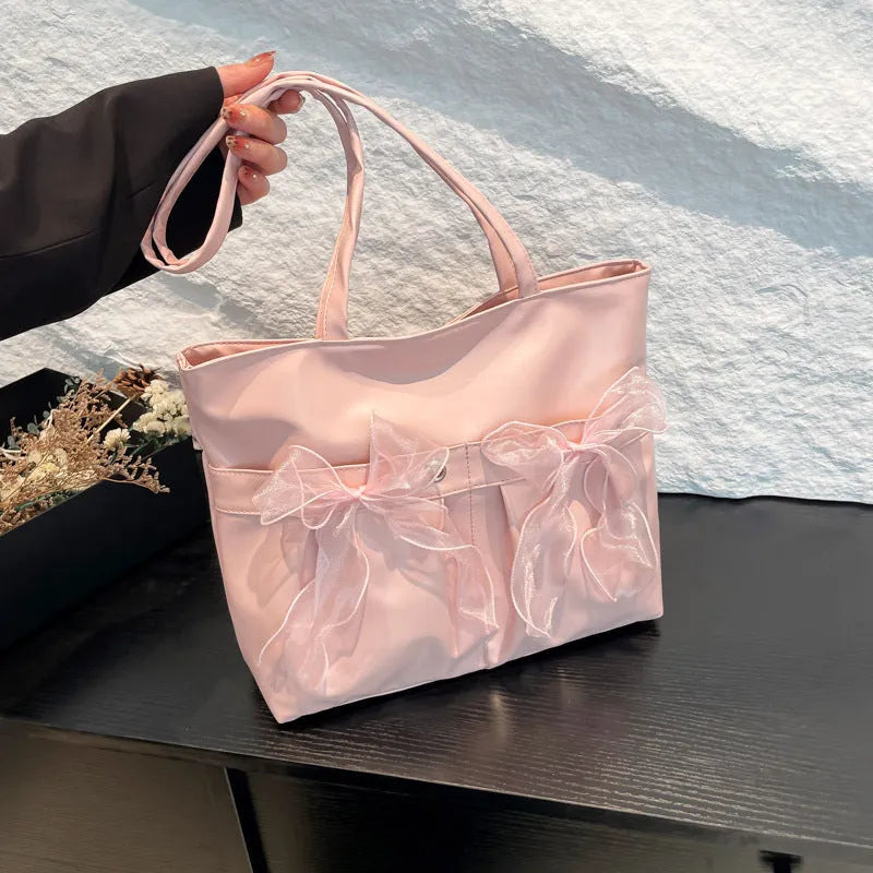 Black college style bow tote bag with double shoulder straps and large main compartment