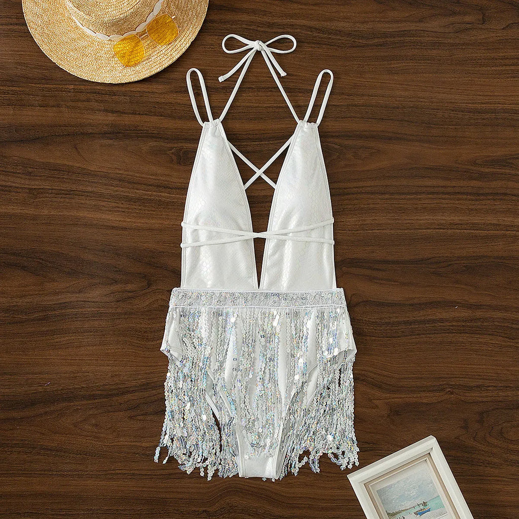 White women's one-piece swimsuit with deep V-neck and tassel detail on a brief cut.