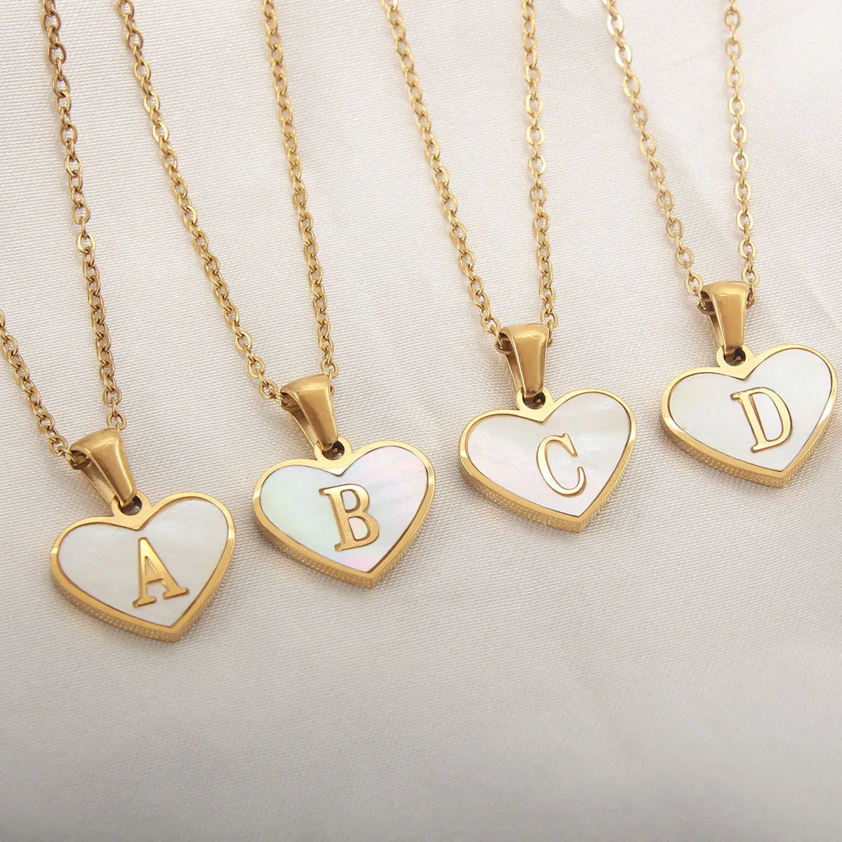 Gold-plated heart-shaped white shell pendant necklace on a stainless steel chain with extendable clasp