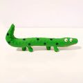 Green cartoon lizard-shaped latex dog chew toy with squeaker on a white background