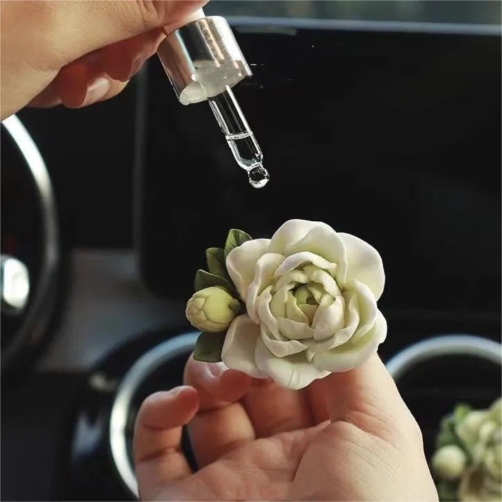 Jasmine scented gypsum solid car perfume clipped to a car air vent in off white or fresh green.