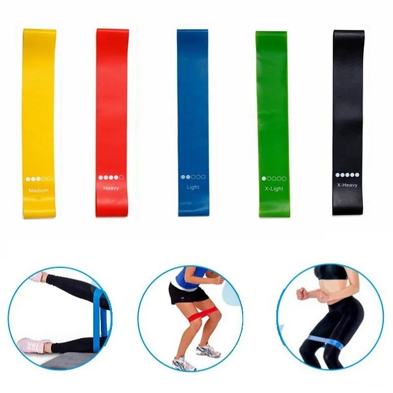 Set of five colour-coded TPE yoga tension straps laid out side by side, showing green, blue, yellow, red, and black options.