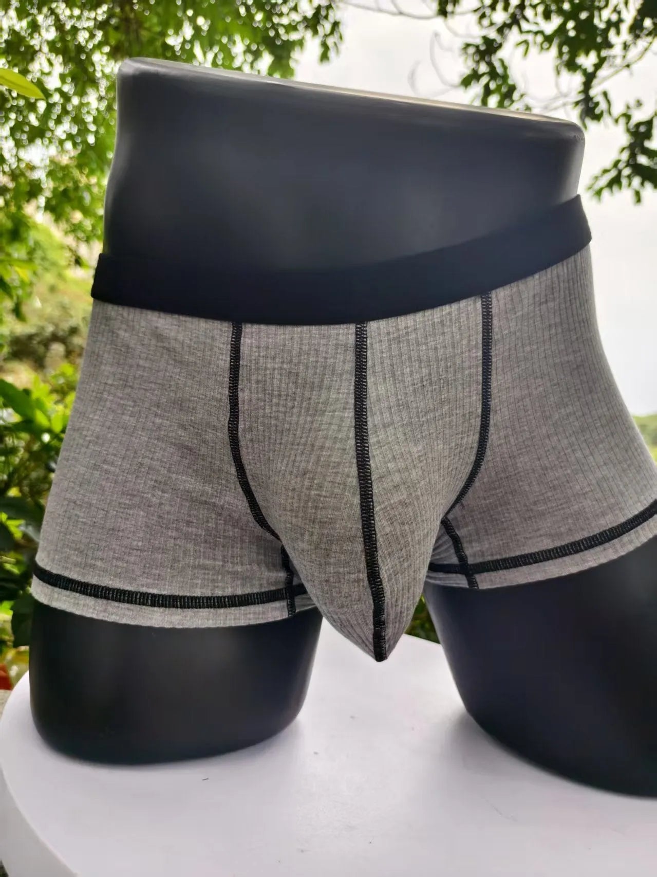 Men's solid colour boxer shorts in breathable fibre fabric on a plain background.