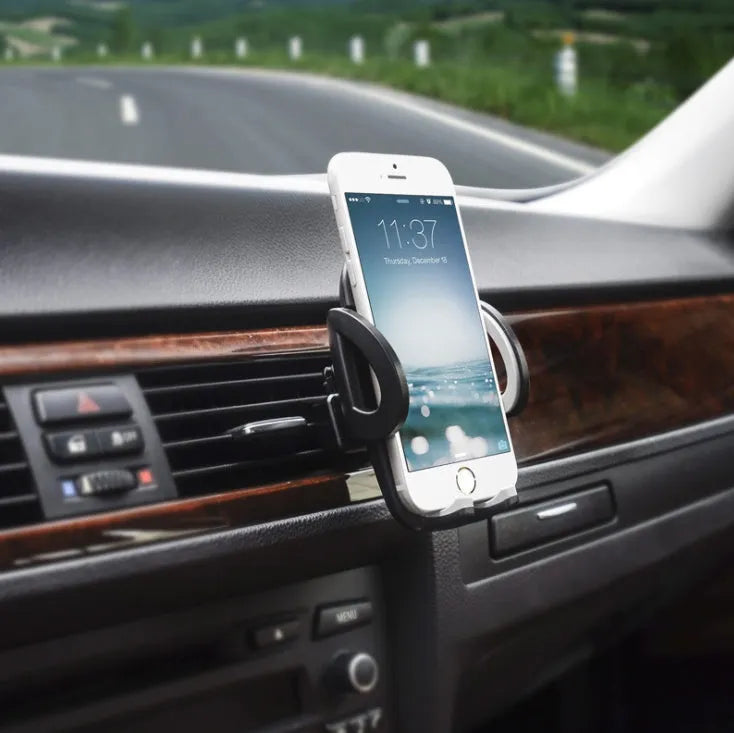Black plastic mobile phone holder clipped to a car air conditioning vent.