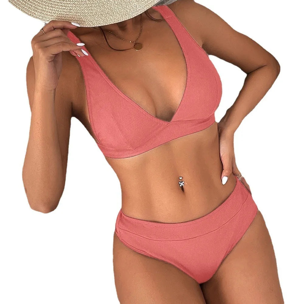 Women's black lace-up front bikini with high-leg split design on a neutral background.