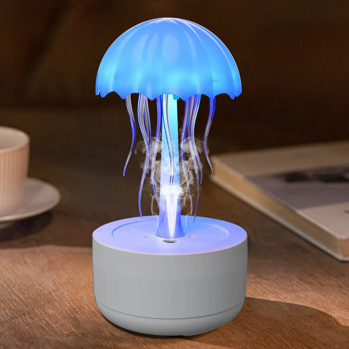 White jellyfish-shaped aroma diffuser and humidifier with glowing coloured LED light on a desk.