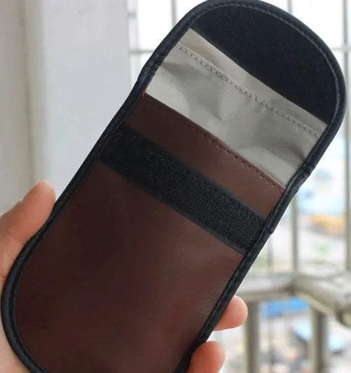 Black microfiber Faraday pouch for blocking mobile phone signals and shielding RFID cards.