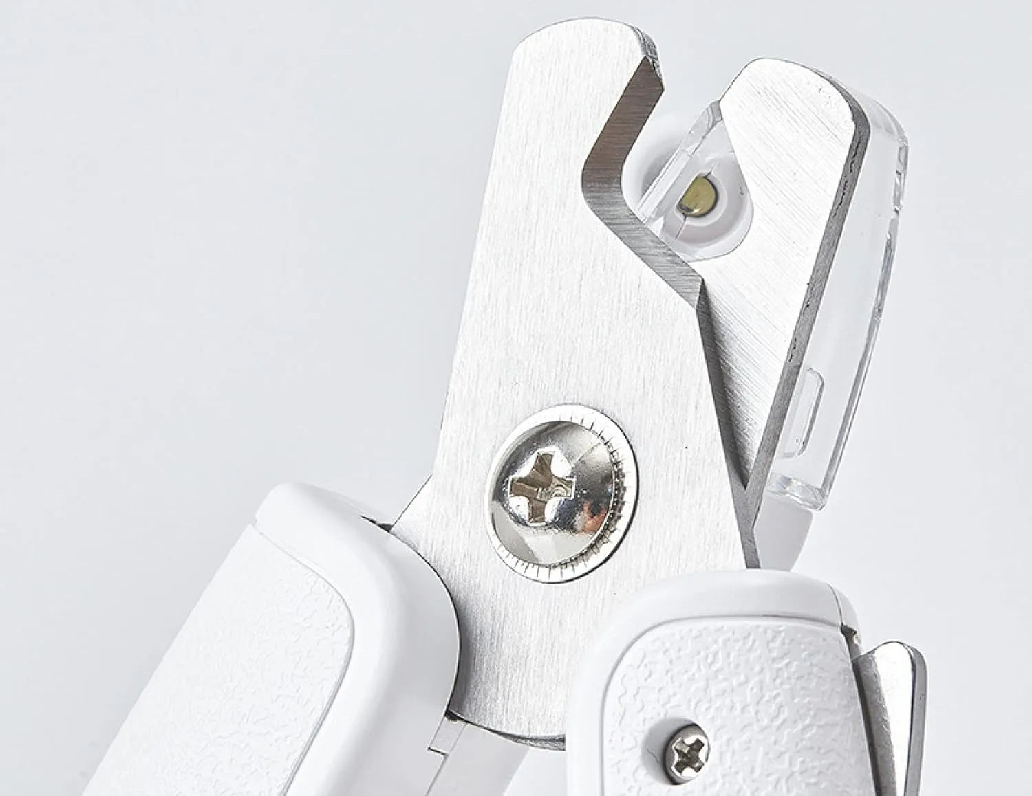 White pet nail clippers with LED light, transparent guard, and leather-like handle next to a nail file.