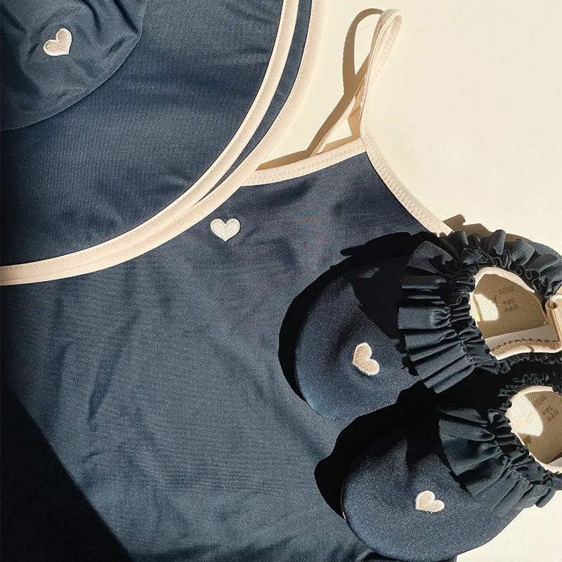 Dark blue split-style briefs swimsuit for baby girls, shown in sizes from 90cm to 130cm.
