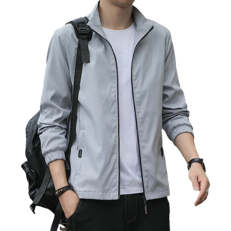 Man wearing a loose fit black Korean style casual jacket with zip pockets.