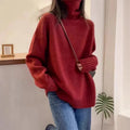 A woman's loose-fitting thick turtleneck sweater in a solid colour with a 3D textured pattern.