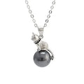 Close-up of a sterling silver cat pendant necklace on a clavicle chain.