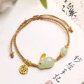 Yellow string bracelet with a geometric Hetian jade charm shaped like a rabbit for women.