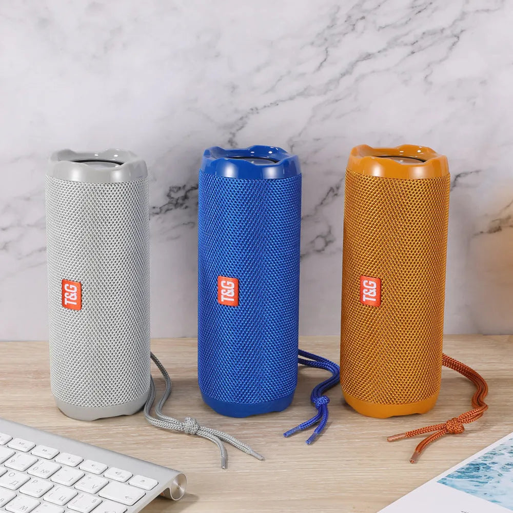 Portable fabric Bluetooth speaker with integrated card holder pocket on side, shown in available colours.