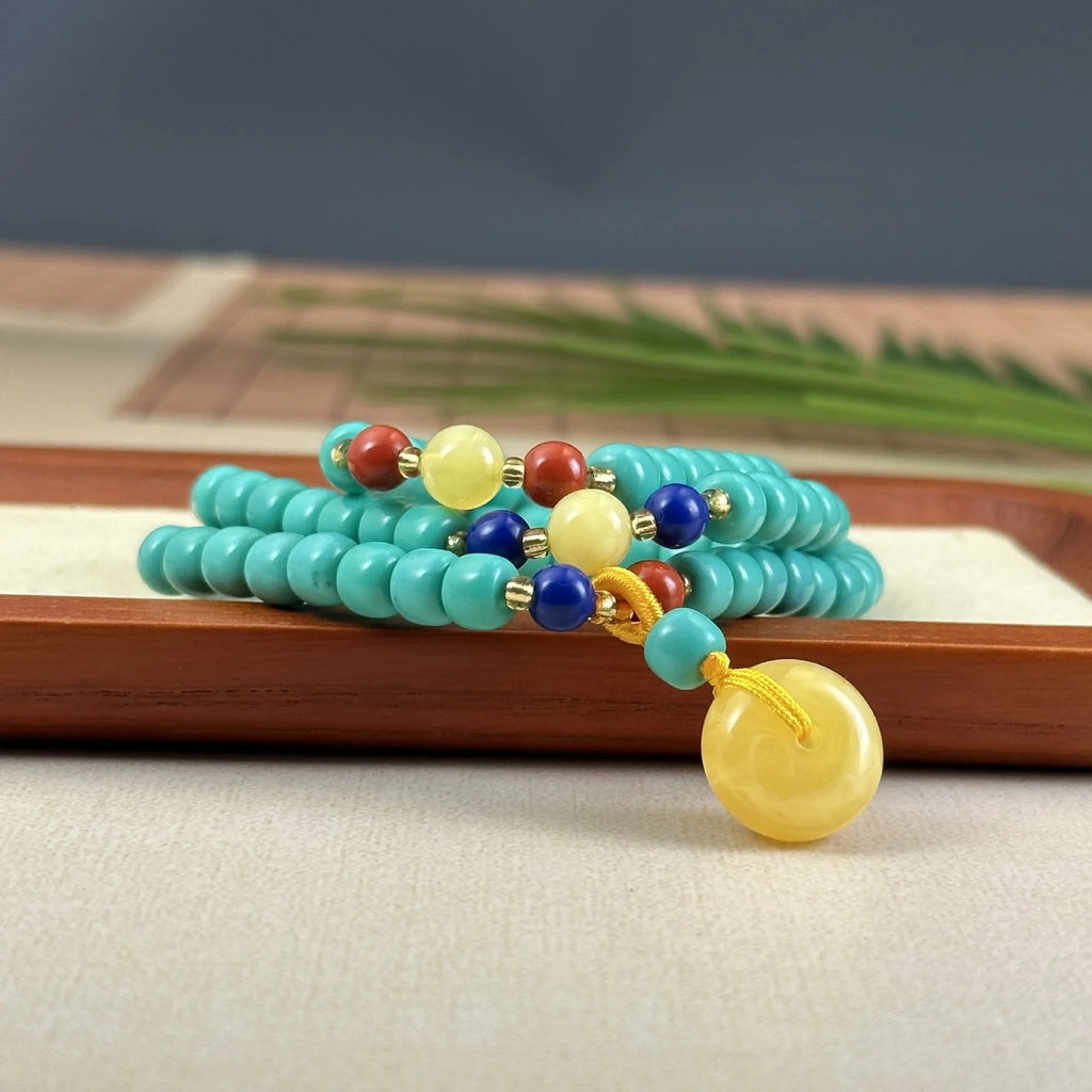 Turquoise mesh flower lucky pendant necklace on a ball bead chain, showing hand-woven detail.