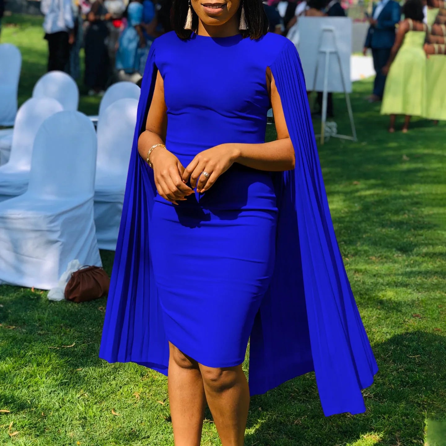 Pleated shawl style evening gown with round neck and long sleeves in formal setting